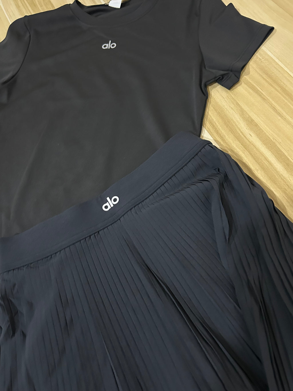 Ensemble Alo Yoga noire femme – jupe plissée et t-shirt assorti premium